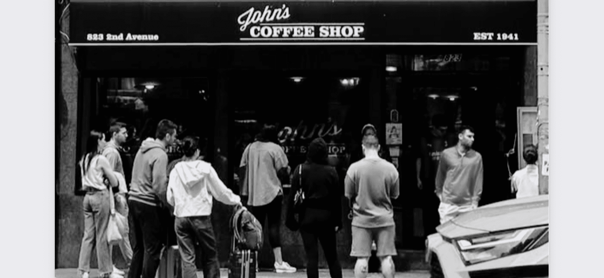 Crowd gathered outside a coffee shop named John's on 2nd Avenue, established in 1941.